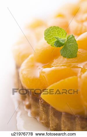 Stock Photo - Orange and peach tart, close up, white background. Fotosearch