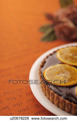 Stock Photograph - Orange tart on plate, colored background. Fotosearch
