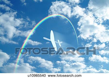 Stock Image - Paper airplane flying through a blue sky and clouds towards a rainbow. Fotosearch