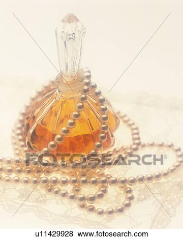 Pearl necklace draped around a perfume bottle View Large Photo Image Stock Photo - Pearl necklace draped around a perfume bottle. Fotosearch