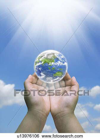 Stock Photograph - Planet earth floating over human hand. Fotosearch
