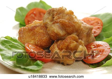 Stock Image - Plate of deep fried chicken, close up, white background. Fotosearch