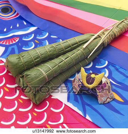 Stock Image - Rice dumplings wrapped in bamboo leaves on a carp streamer. Fotosearch