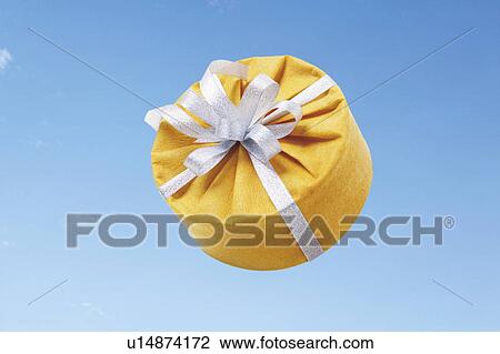Round gift box wrapped in yellow paper and topped with a bow View Large Photo Image Stock Image - Round gift box wrapped in yellow paper and topped with a bow. Fotosearch