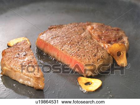Stock Image - Steak frying in a pan. Fotosearch
