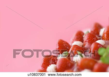 Stock Image - Strawberry tart, close up, red background, copy space. Fotosearch