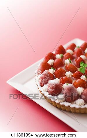 Picture - Strawberry tart on plate, red background. Fotosearch