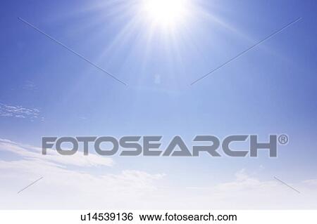 Sun and clouds in blue sky, lens flare, copy space View Large Photo Image Stock Photograph - Sun and clouds in blue sky, lens flare, copy space. Fotosearch