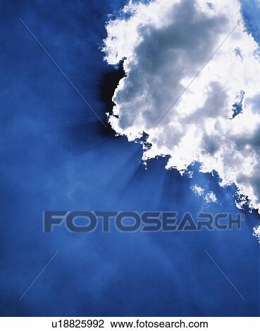 Stock Image - Sun shining through clouds. Fotosearch