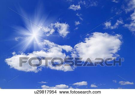 Picture - Sunbeams and clouds in a blue sky. Fotosearch