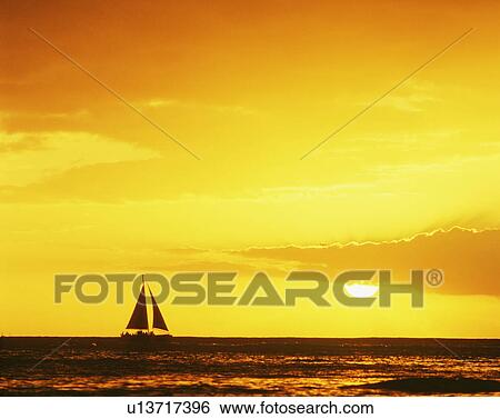 Stock Photograph - Sunset over boat at Waikiki Beach, Oahu, Hawaii Islands, USA. Fotosearch