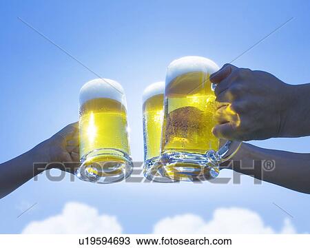Three people toasting glass of beer under the sky View Large Photo Image Stock Image - Three people toasting glass of beer under the sky. Fotosearch