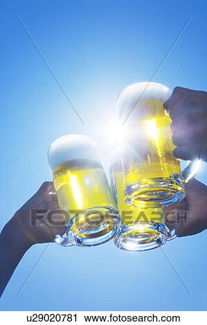 Three people toasting glass of beer under the sky View Large Photo Image Stock Image - Three people toasting glass of beer under the sky. Fotosearch
