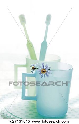 Stock Photography - Toothbrushes in cup in bathroom. Fotosearch