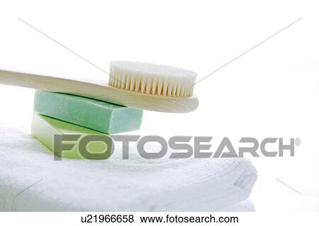 Stock Photo - Towels, bars of soap and back brush in bathroom. Fotosearch
