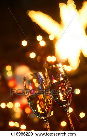 Stock Image - Two champagne flutes on a patio. Fotosearch