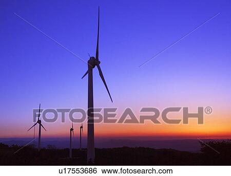 Stock Photograph - Wind turbines on hill at sunrise. Fotosearch