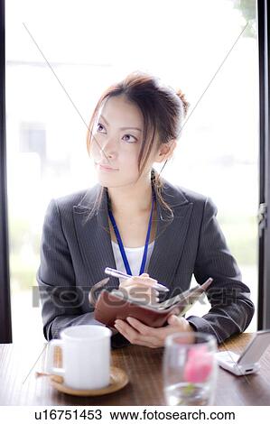 Young businesswoman holding personal organizer in cafe, looking away View Large Photo Image Stock Image - Young businesswoman holding personal organizer in cafe, looking away. Fotosearch