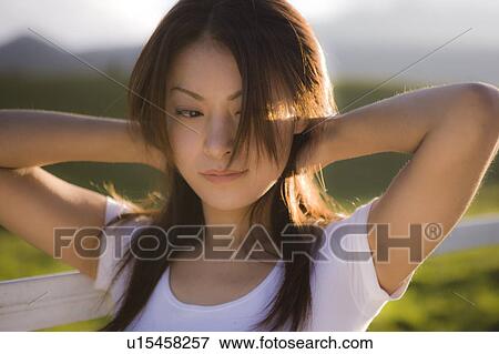 Stock Photo - Young woman beside pasture, Tochigi prefecture, Japan. Fotosearch