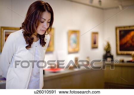 Young woman in art gallery View Large Photo Image Stock Image - Young woman in art gallery. Fotosearch