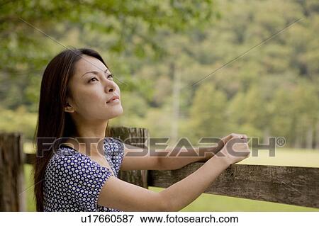 Young woman leaning on fence, looking up, Tochigi prefecture, Japan View Large Photo Image Stock Photo - Young woman leaning on fence, looking up, Tochigi prefecture, Japan. Fotosearch