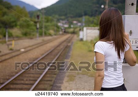 Stock Image - Young woman standing on platform. Fotosearch