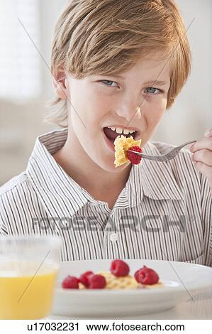 Stock Image - Child eating breakfast. Fotosearch