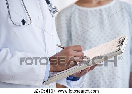 Doctor studying patient chart View Large Photo Image Stock Photo - Doctor studying patient chart. Fotosearch