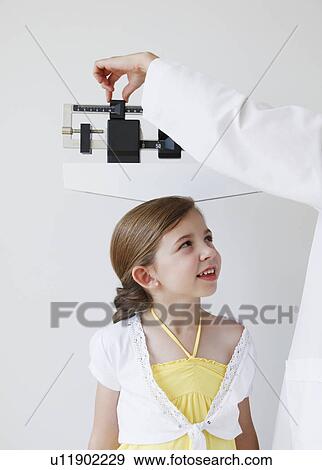 Doctor weighing child View Large Photo Image Stock Photo - Doctor weighing child. Fotosearch