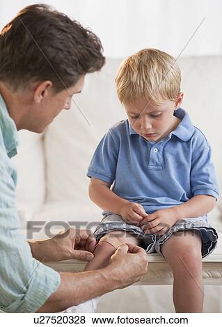 Stock Photo - Father treating childs injury. Fotosearch