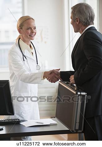 Female doctor greeting salesman View Large Photo Image Stock Image - Female doctor greeting salesman. Fotosearch