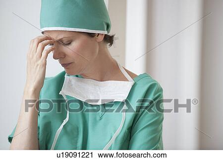Stock Image - Female doctor in thought. Fotosearch