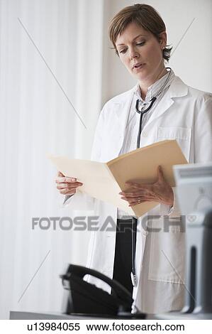 Stock Photography - Female doctor reviewing notes. Fotosearch