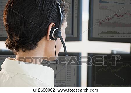Stock Image - Female trader studying screens. Fotosearch