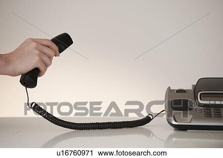 Stock Image - Hand on phone receiver. Fotosearch