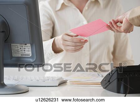 Stock Image - Hand passing note to office worker. Fotosearch