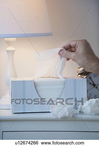 Stock Photograph - Hand pulling tissue out of box. Fotosearch