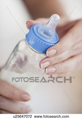 Hands holding baby bottle View Large Photo Image Stock Image - Hands holding baby bottle. Fotosearch