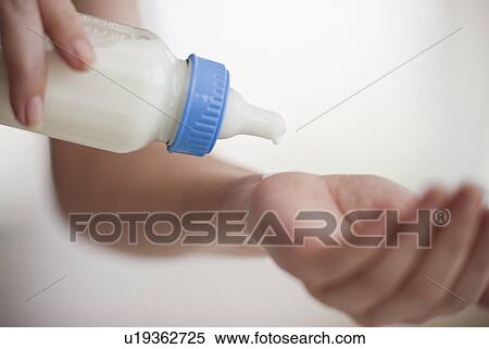Stock Photography - Hands holding baby bottle. Fotosearch