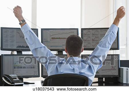 Stock Image - Male trader raising arms in success. Fotosearch