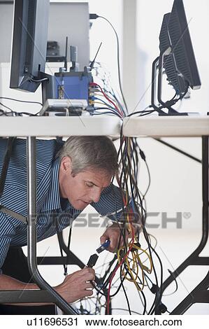 Man under table working on networked computers View Large Photo Image Stock Image - Man under table working on networked computers. Fotosearch