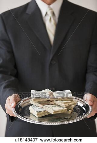 Stock Photo - Money on silver platter. Fotosearch