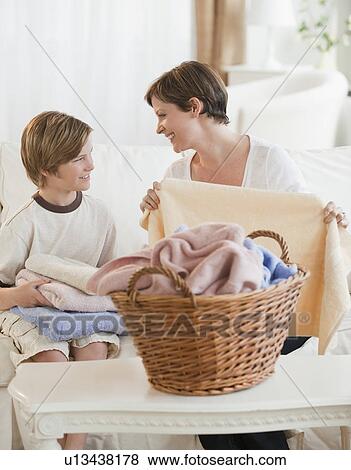 Mother and child folding laundry View Large Photo Image Stock Photo - Mother and child folding laundry. Fotosearch