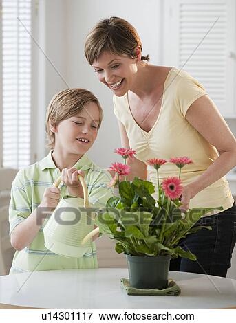 Stock Photo - Mother and chilld watering plants. Fotosearch