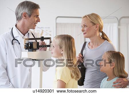 Stock Image - Mother and daughters at Doctor's office. Fotosearch