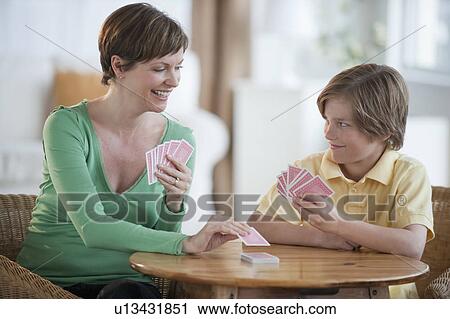 Stock Image - Mother and son playing cards. Fotosearch
