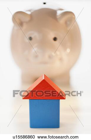 Stock Image - Piggy bank and symbolic house. Fotosearch