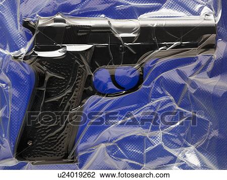 Stock Image - Shrink wrapped hand gun. Fotosearch