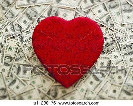 Symbolic red heart wtih US dollars as background View Large Photo Image Stock Photograph - Symbolic red heart wtih US dollars as background. Fotosearch