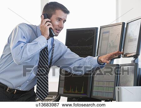 Stock Photo - Trader studying computer screens. Fotosearch